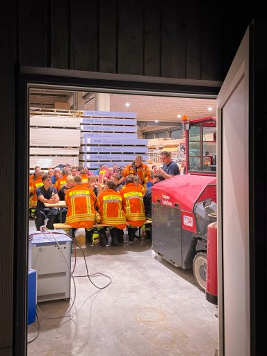 Mitglieder der Feuerwehren Satteldorf und Kirchberg sowie der Jugendfeuerwehr sitzen nach der Übung bei Bauer Holzbau zur gemeinsamen Jause zusammen.