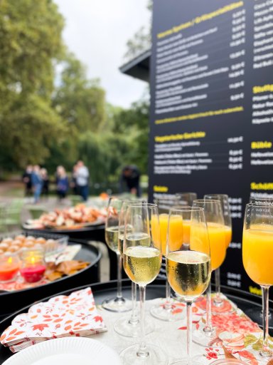 Sektgläser, Orangensaft und kleine Häppchen stehen beim Empfang zur Wiedereröffnung des Kiosks KÖSK im Unteren Schlossgarten Stuttgart bereit.